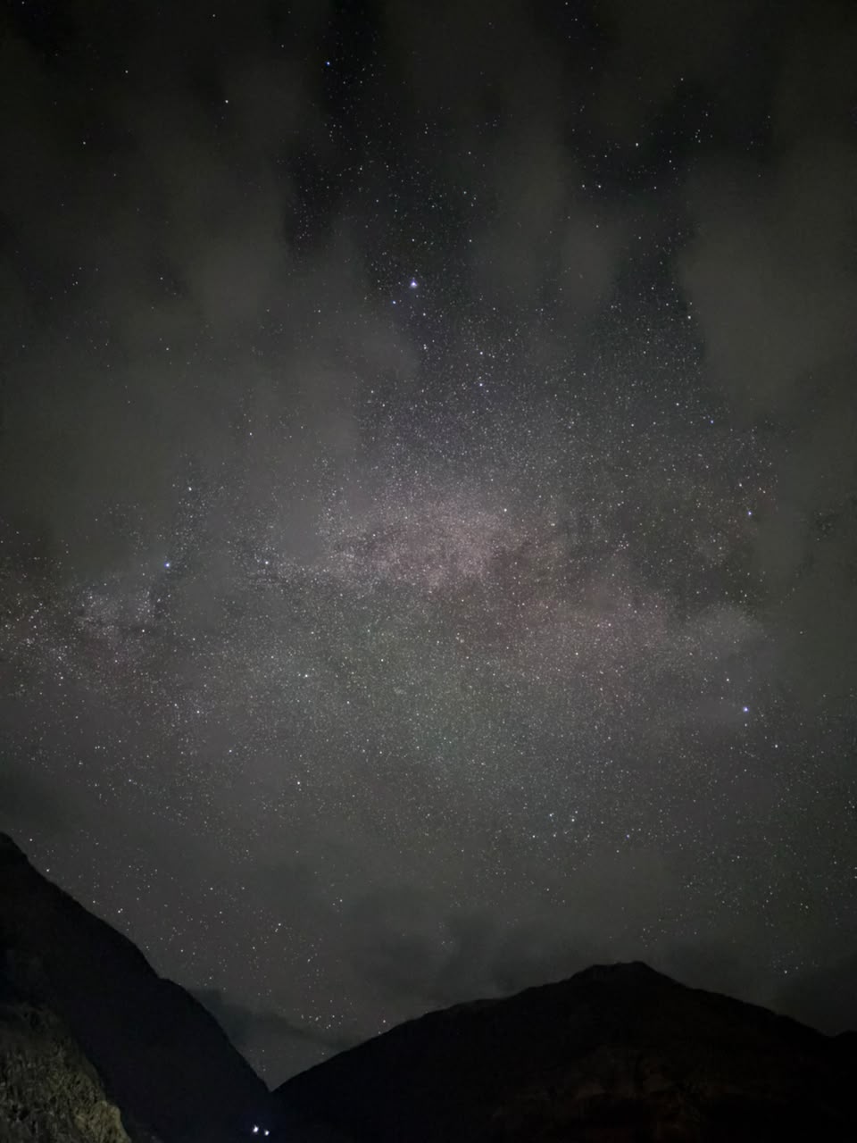 Milky Way glowing through thin clouds above the Ladakh mountains