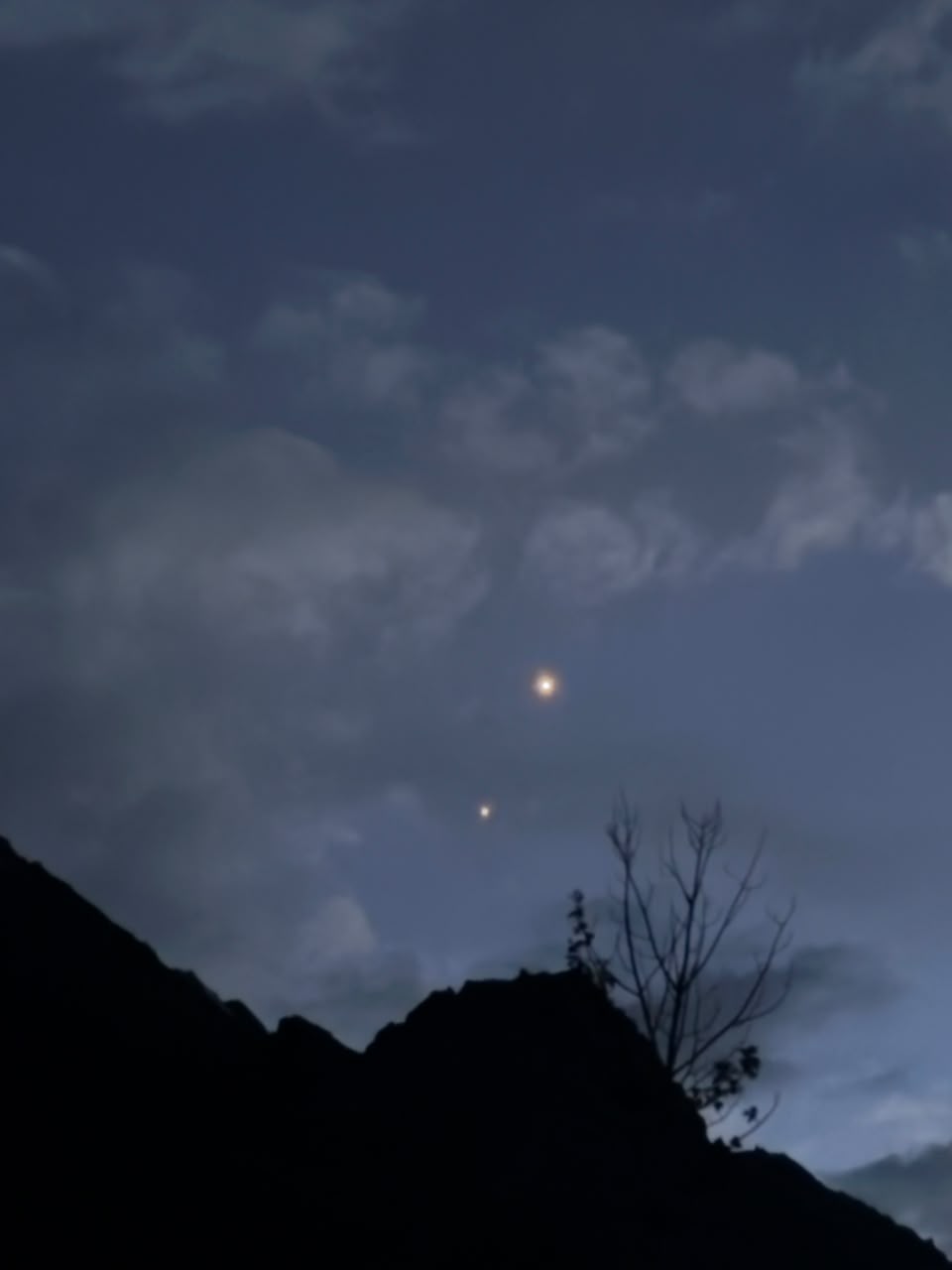 Two bright planets close together in the Ladakh twilight sky above a ridge