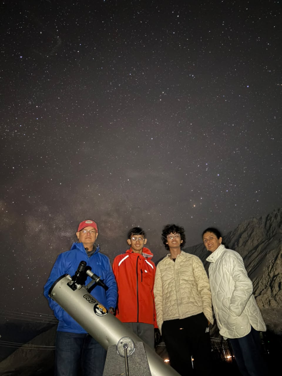 Family stargazing through a telescope on a clear Ladakh night