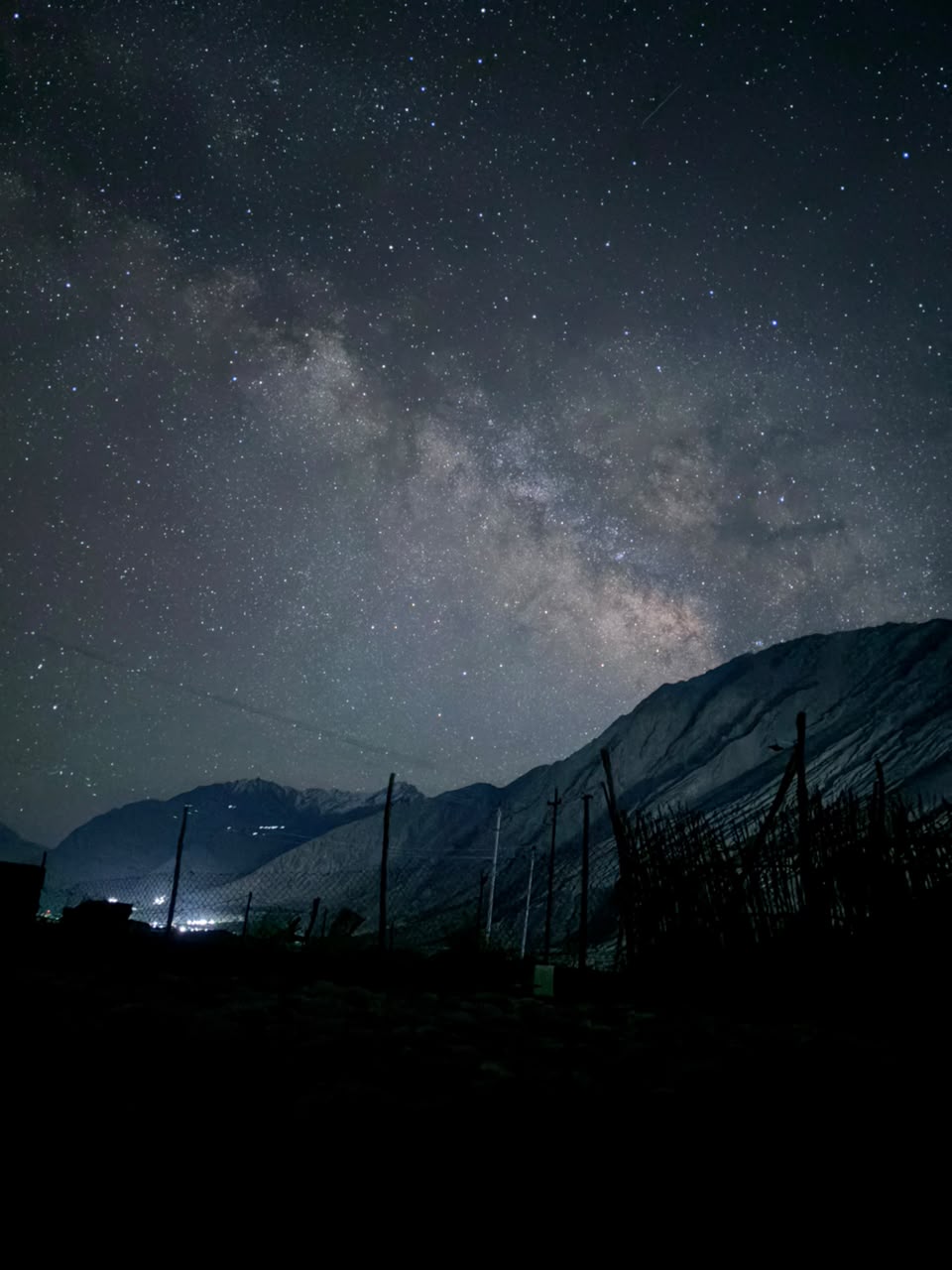 Milky Way arching over the Ladakh mountains and village lights
